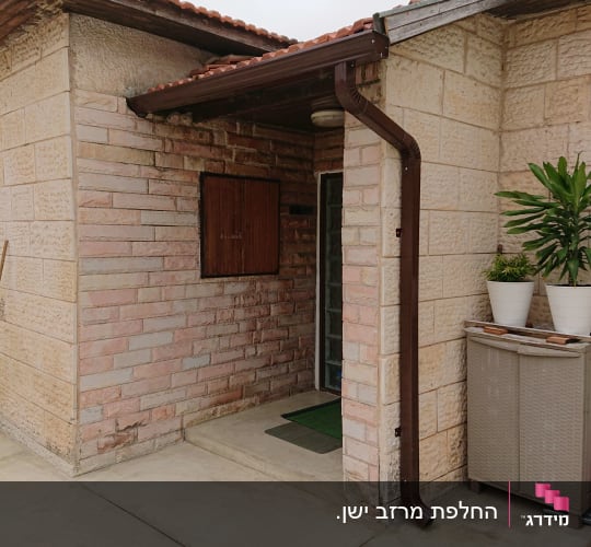 מרזב חום מחובר לגג רעפים אדום